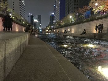 People walking on city street at night