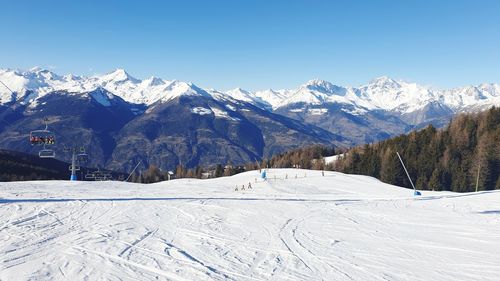 Scenic view of snowcapped mountains against clear blue sky