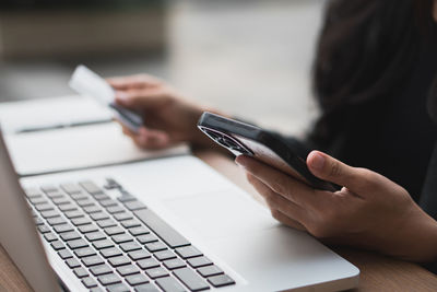 Midsection of woman using laptop on table