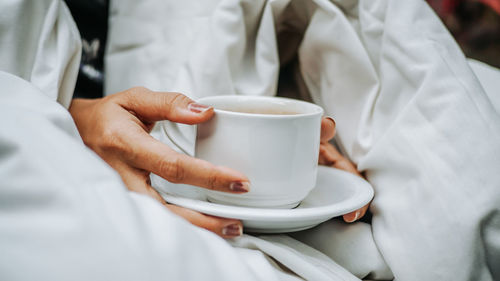 Midsection of woman holding coffee cup