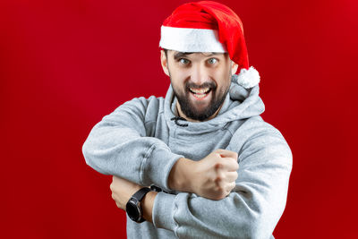 Portrait of man wearing hat against red background