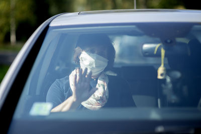 Reflection of man in car