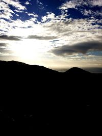 Scenic view of silhouette mountains against sky at sunset