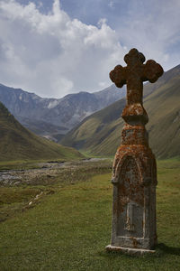 View of cross on land against sky