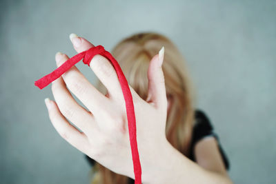 Close-up of woman tied fabric in finger