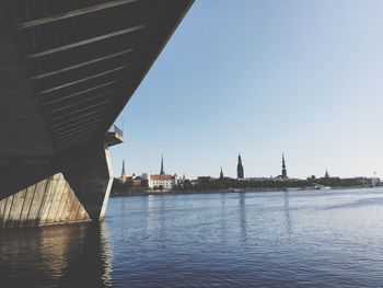 Scenic view of river by city against clear sky