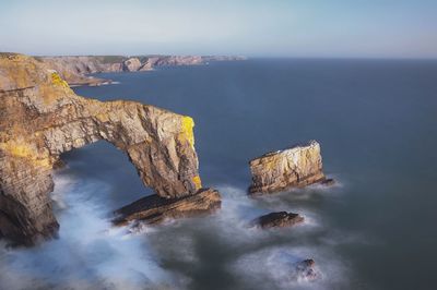 Rock formations in sea against sky