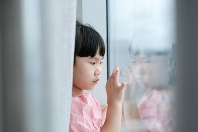 Portrait of woman looking through window
