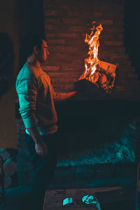 Midsection of man with fire burning at night