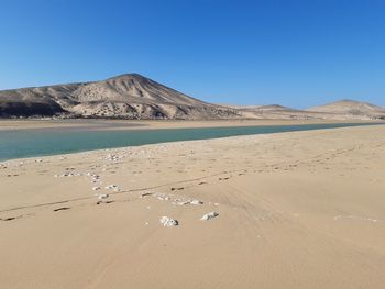 Scenic view of desert against clear blue sky