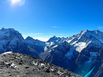 Scenic view of snowcapped mountains against blue sky