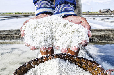 Farmers holding salt when producing salt traditionally in indonesia
