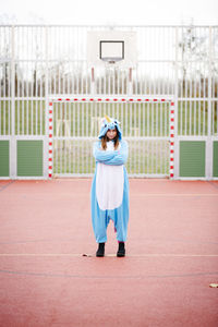 Full length portrait of young woman standing outdoors