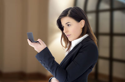 Young woman using mobile phone in office 