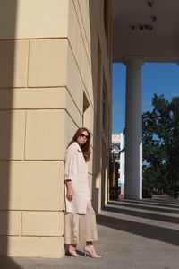 Young female model posing against wall