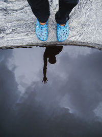 Low section of person reflection in puddle