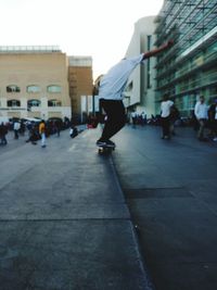 Rear view of man skating on skateboard in city street