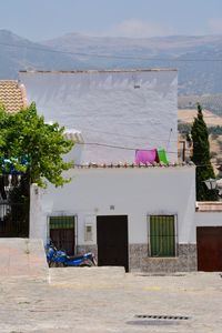 Clothes drying on building by house against sky