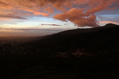 Scenic view of silhouette mountains against dramatic sky