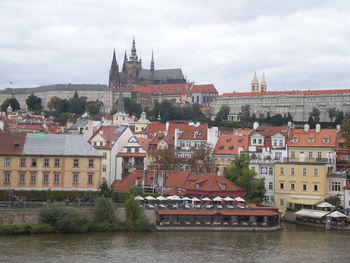 Buildings in city against cloudy sky