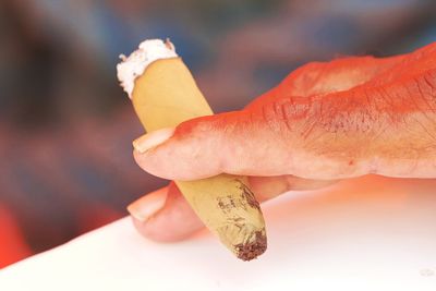 Close-up of hand holding tobacco product