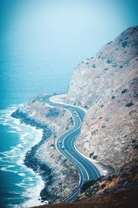 High angle view of road by sea against clear sky