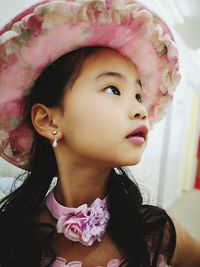 Close-up of girl in hat looking away at home