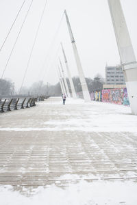 Bridge over snow covered city against sky