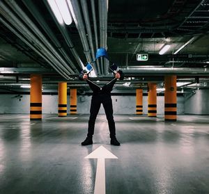 Digital composite image of man holding hooded shirt in basement