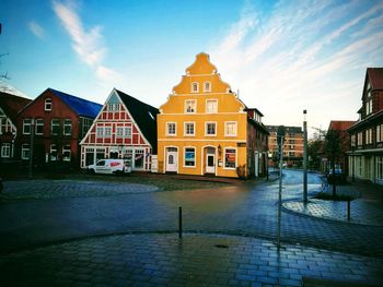 Houses by street against sky in city during winter