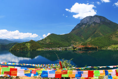 Scenic view of lake by mountains against sky