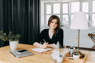 Business girl freelancer in casual clothes works using wireless technology in the home office