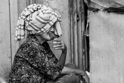 Senior woman wearing towel while sitting outdoors