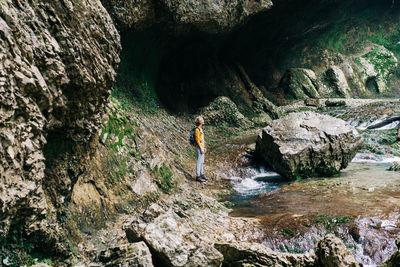 Woman trekker explores the canyon while walking along the creek