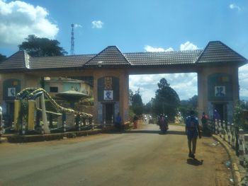 People on street by buildings against sky