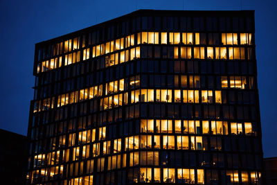 Office building exterior with glowing lights in windows at night city. vienna city downtown 