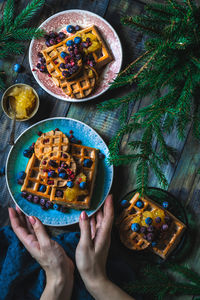 Cropped hand of woman holding food on table