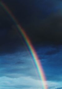 Low angle view of rainbow against blue sky