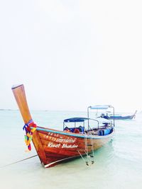 Ship moored on sea against clear sky