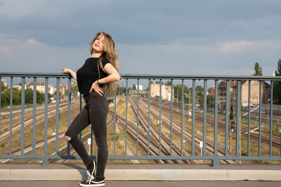 Full length of woman standing on railing against bridge