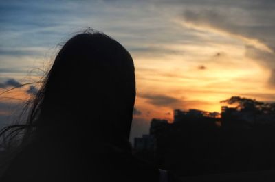 Close-up of silhouette woman against sunset sky