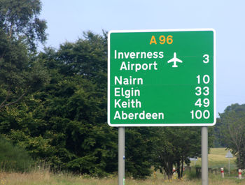 Close-up of road sign against trees