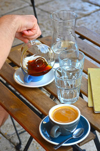 Close-up of hand holding drink on table