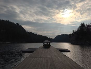 Pier on calm lake at sunset