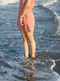 Low section of woman standing on beach