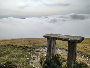 Wooden posts on field against sky