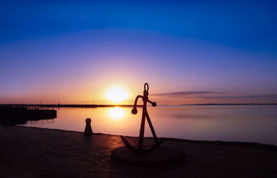 Silhouette boat on beach against sky during sunset