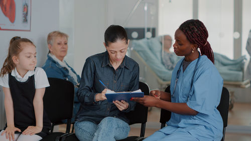 Nurse getting document signed from patient