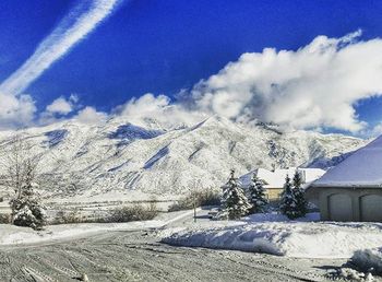 Scenic view of snow covered mountains against blue sky