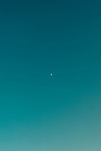 Low angle view of moon against blue sky